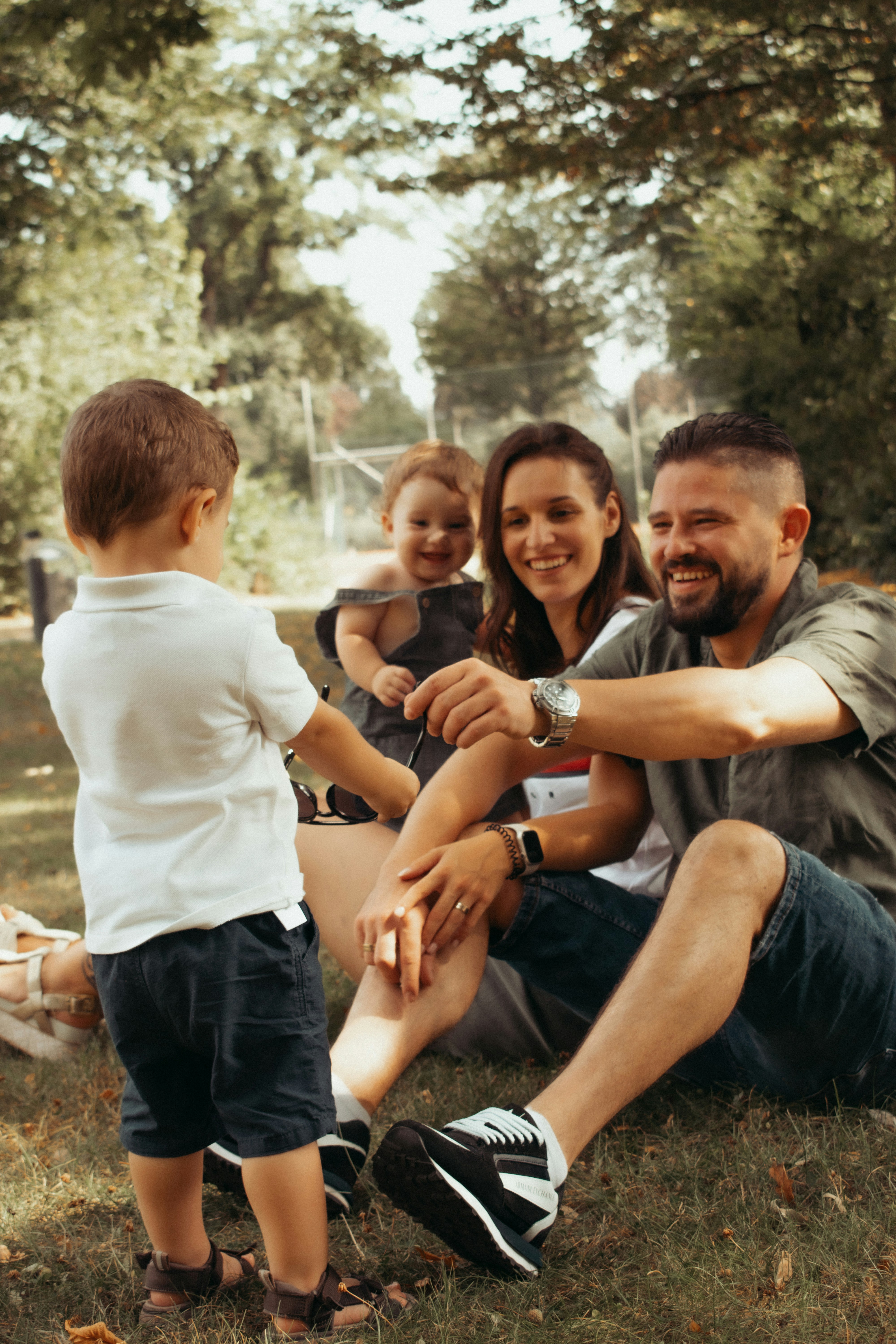 A stepparent and stepchild sitting apart on a couch, eyes meeting quietly across the room